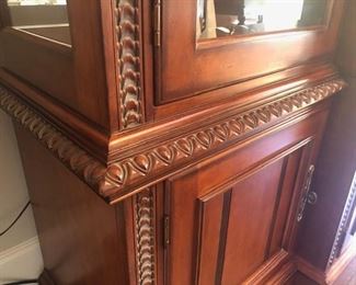 Entertainment Center, Solid wood, hand carved - 101”wide x 86” high at midpoint  x 24.5” front to back (deep). Lights inside of 
each tower - touch on via hinge, $975