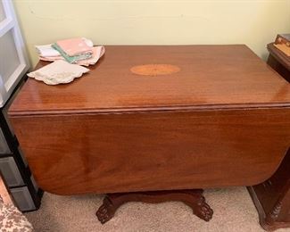 Early antique drop leaf table with claw feet and inlaid design on top. 
