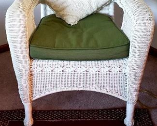 "Wicker" arm chair & one of several throw rugs