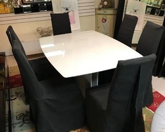 Milano White gloss expandable dining table with six grey slipcover chairs. Table pulls apart and leaf pops up. Originally $6500 sale price $2250. Excellent condition!