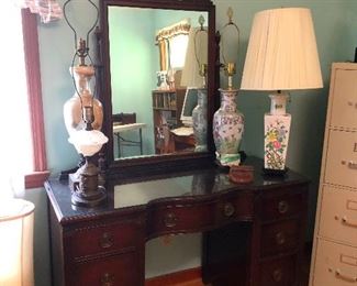 Pretty antique vanity bedecked with an overage of lamps
