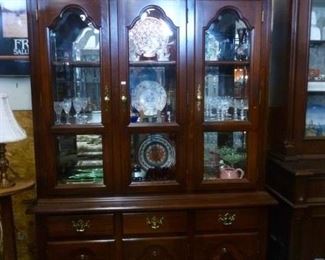 This china cabinet has three beveled glazed doors, glass shelves, interior lights, over base cabinet of 3 drawers over 3 cupboard doors.  Offered now at only $100 because we do not wish to move it again.
