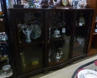 This large display cabinet has three glazed doors, of which the middle is serpentine, adjustable interior wood shelves, locking keys.  Originally not for sale, I have decided to offer it at $1,900.   We have working keys/locks.