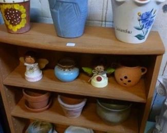 Photo shows about one quarter of the variety of flower pots we have for sale, these displayed on a particle board CD rack, the rack price now at $24.  Pots range $4 to $12 each.