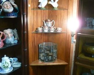 Quarter-round corner display unit with light in top over 2 glass shelves over solid shelf over base shelf, now reduced to $50