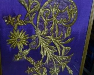 This type of gold thread embroidery is called "couched" embroidery because the threads are applied over slight stuffing.  This piece probably from a robe, later attached to a new backing and framed, @ $94