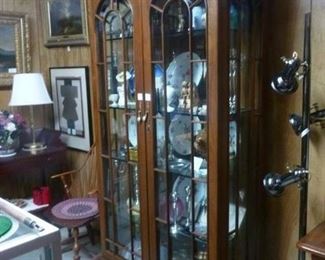 Display cabinet in rosewood (from Indonesia ?), having elbaorate pediment oveer two glazed and mullioned doors, interior mirrored back and glass shelves, lighted, now reduced to $250
