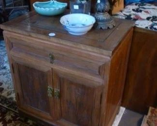 Asian-design cabinet in teak (?) having drawer of 2 doors, the top with incarved scene @ $50