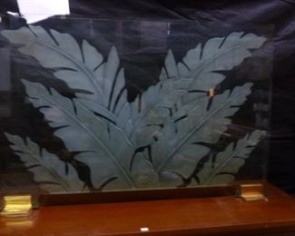 This is as fire screen from Hawaii, made on plate glass with acid-etched leaves, seated in two polished brass feet/stands.  Overall probably 2-1/2'h x 4'w.  Accompanying typed document states that it was purchased for $2,200.  We are offering it now @ $900.