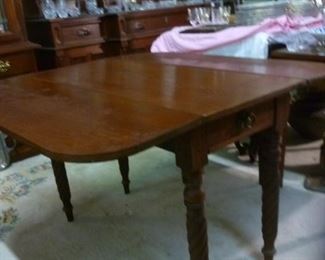 Note the beautiful spiral twist legs and apron drawer of this American antique double dropleaf table.