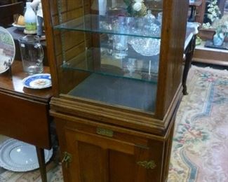 Here are 2 pieces put together.  Top is an antique showcase from a general stored having glass top and shelves, opening from the back since it would have sat on a counter in the store, offered @ $100.  Bottom is a cabinet with a swivel top, designed as an old ice box, also offered at $100.