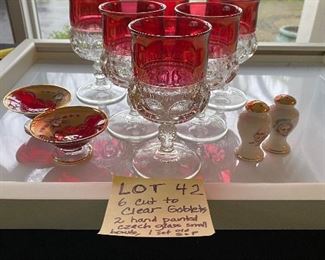 Lot 42.  $12.00. Set of 6 Red and Clear Glass Goblets (pressed), two Bohemian hand-painted finger bowls (one has tiny chip on rim)  and an interesting and antique salt & pepper shaker set(perfect) featuring George and Martha Washington.