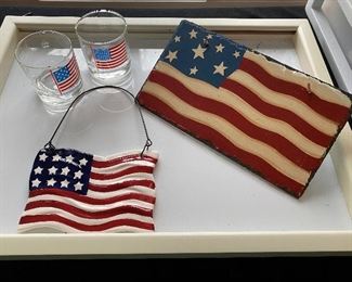 Lot 46.  $20.00   American Flag Lot of 2 rocks glasses, and two flag wall or door hanging plaques.  The glasses feature an early American flag on left, and a 48-star flag on the right. 