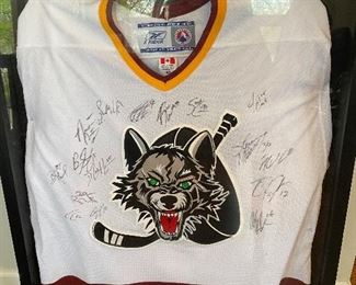 Lot 50.  $150        Here's a fun framed Chicago Wolves hockey jersey, signed by the team when they won the American Hockey League championship.  It's framed in a heavy-duty deep shadow  frame.  What a great gift for a hockey fan!