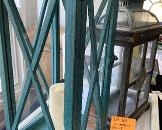 Lot 60.  $32  Two outdoor lanterns.  The green one is made of wood with missing glass on two sides, vintage-inspired and 28" tall.  The other has a weathered look and is 20" tall
