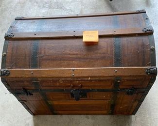 Lot 101.  $65.  Vintage or Antique wood trunk.  Good Shape, has lining with some imperfections.  Cool Details.  Exterior has interesting wrapping on it.  30 inches long, 19 inches wide, 22 inches tall