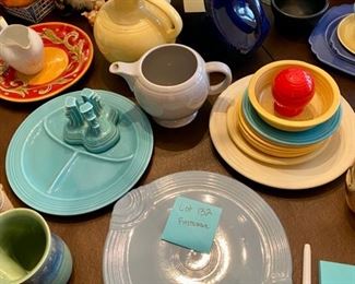 Lot 132.  $125  16 Random Piece Fiestaware collection, some hard to find.  Includes Chop Plate with handles (vintage) in gray, Divided serving plate in Turquoise, I'm not sure what you call the piece standing on the turquoise plate., One yellow Pitcher, a large Navy Disc Pitcher, an Orange Red Salt shaker, a yellow small cereal bowl, a turquoise bread & butter plate, 5 butternut bread/butter or saucers, one pale yellow luncheon plate, one gray Pitcher, and one rimmed plate or soup bowl under the stack of yellow.