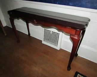 Queen Anne-style compressed wood console table with 2-tone top and applied shell carving. Cherry color finish. 48"w X 27"h X 16"d. PRICE: $75.00