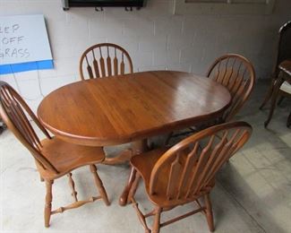 Oak dinette table with (4) chairs and (1) large leaf. With leaf, this table is 55.5"w X 36"d X 30.5"h.  Without leaf, the table is 36" round. Each chair is 18"w X 17.5"d X 38"h. (Some wear). PRICE: $175.00