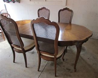 Vintage "Thomasville" French-style dining table with carved legs and (2) leaves and (4) side chairs with caned backs. Each leaf is 20" wide. Without leaves, the table is 42" diameter, 42"w X 30"h. Each side chair is 20.5"w X 18"d X 44.5"h. comes with custom pads. Originally purchased at Cope's Furniture in Alliance. Great condition for age! PRICE: $250.00