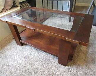 Mission-style cocktail table with beveled glass top and cherry-color finish. 48"w X 26.5"d X 20"h. PRICE: $100.00