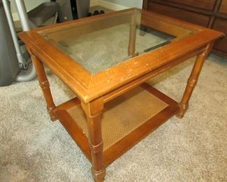 End table with woven base and beveled glass top. 21"w X 27"d X 21"h. Light wear. PRICE: $35.00