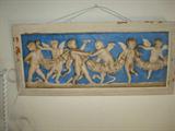 Cherubs playing on wood plaque