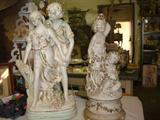 Vintage man and women statue next to a cherub statue