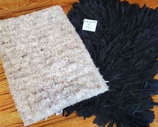 $15 - 2 Rugs. Beige one is Laura Ashley 17.5" x 25.5". Black one is app/ 24" x 34"