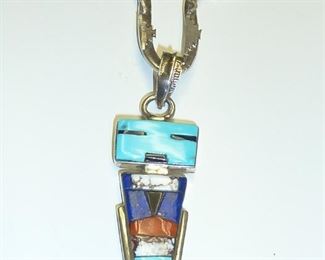Signed piece from the eighties by Navajo artist BURT GEORGE.  Turquoise, Lapis, Coral, and other stone inlay.  Pendant part is 2 5/8" tall including bale.  One of a kind!  $445