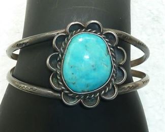 Old hand stamped Native American bracelet with gorgeous turquoise stone.  Face is 1 1/4" high, and it weighs 21 grams.  $138