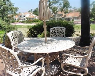 50% OFF   Hanamint cast aluminum lazy susan patio table, 4 swivel chairs. Some paint loss. $500. Umbrella with stand $75.