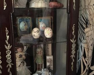 The contents of the cabinet, dolls, hand painted eggs, porcelains, tea sets and lots more!