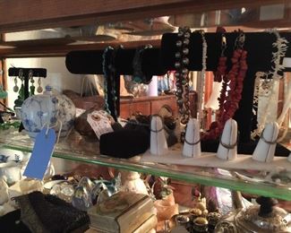 Looking from the back of the showcase, vintage coral jewelry, vintage enamel pieces, rings, vintage prayer books and bibles, sterling pieces, glass eggs from Mount Saint Helens, Miessen