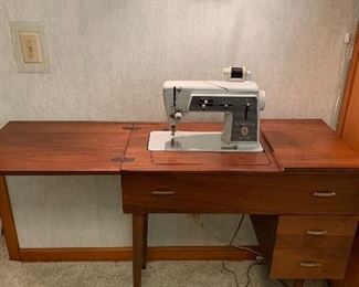 Singer sewing machine in cabinet. Includes chair, Not shown.