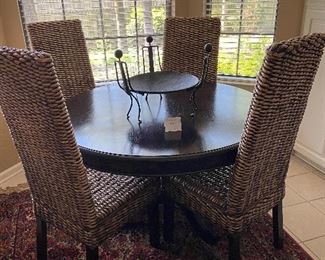 Awesome round pedestal table with woven chairs.