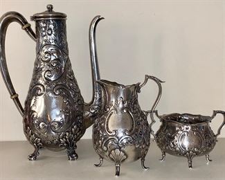 Item 65: Three Piece Antique Gorham Sterling Silver Repousse Chocolate Set, (Teapot appx 8" tall, sugar appx.  2.5 x 2", creamer appx. 1.5 x 4"). Repair needed to straighten foot on teapot: $425
