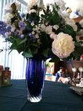 Beautiful silk flower arrangement in lovely blue glass vase.