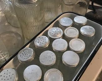Shakers of clear ribbed glass with matching jars