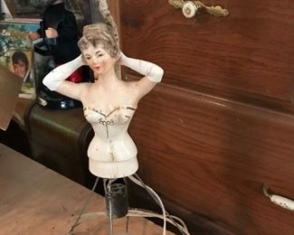 This is the top to a lamp.  She just needs a skirt!