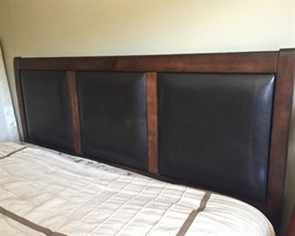 King size bed with leather/wood headboard.