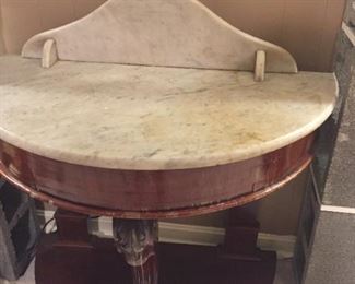 Semicircle wood table with marble top.