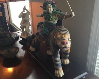 Asian Man riding tiger.
