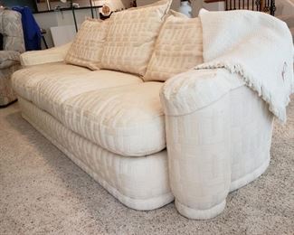 White upholstered sofa with curved arms