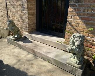 pair of concrete lions (one leg on each cracked)