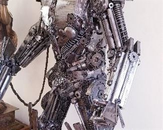 LOT X- $22,000- Optimus Prime by Sculptor " Mr. Santo" from Elena Bulatova Fine arts. This rendition is made out of recycled car and motorcycle parts  ( Approximately 84"  tall x 5 ft wide x 38 " deep). More info on artist can be found on https://www.elenabulatovafineart.com/mr-santo