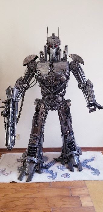 LOT X- $22,000- Optimus Prime by Sculptor " Mr. Santo" from Elena Bulatova Fine arts ( Approximately 84"  tall x 5 ft wide x 38 " deep). This rendition is made out of recycled car and motorcycle parts. More info on artist can be found on https://www.elenabulatovafineart.com/mr-santo