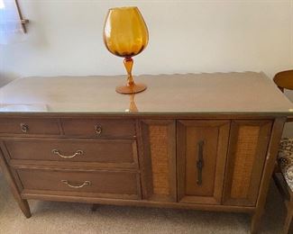 96. Mid Century Traditional Sideboard. 3 Drawers. Flatware Drawer, Storage 58x25 Custom Glass Top. Grass Cloth Design on Cabinet Door. To the right some Dings. $75 Mid Century Viking Center Piece $20