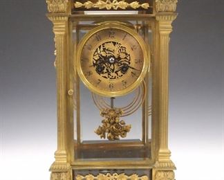 A turn of the century French crystal regulator by L. Marti, originally retailed by Le Roy, Paris.  8-day time and strike movement with pierced gilded, dial and Arabic numerals, floral swag pendulum.  Gilded bronze case with beveled glass panels and applied swags with foliage.  Minor wear, running when cataloged.  13 1/2" high.  ESTIMATE $800-1,200