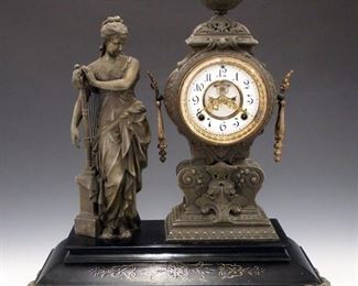 A turn of the century Ansonia "Music" model figural clock.  8-day time and strike movement with two part porcelain dial and Roman numerals with visible escapement.  Cast Spelter case with a figure of the Muse holding a harp standing beside the clock.  Original finish with wear and losses, edge flakes on door glass, running when cataloged.  21 3/4" high.   ESTIMATE $800-1,200